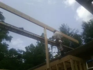 Carpenter setting a ridge beam over a new addition frame — Ice Dam Removal by Roofing Brothers in Fairchance