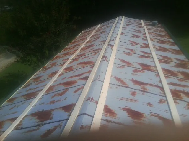 Rusted metal roof panels with new wood purlins before replacement — Storm Damage Roof Repair in Fairchance by Roofing Brothers