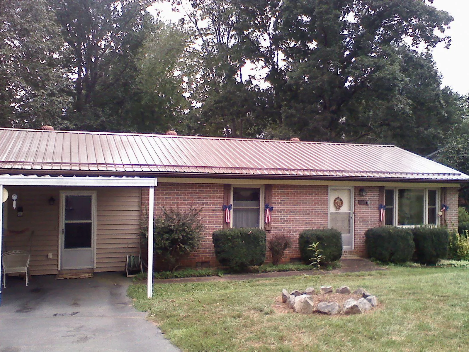 Bronze metal roof and carport on a brick ranch home — Roof Repair work by our crew in Fairchance